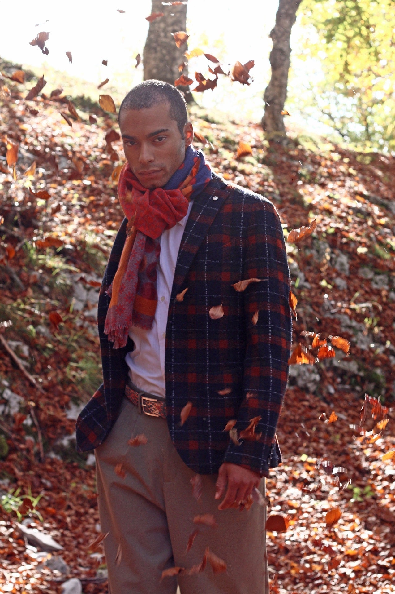 our model during an autumn leaves falling wearing a jacket an orange scarf and an orange painted belt