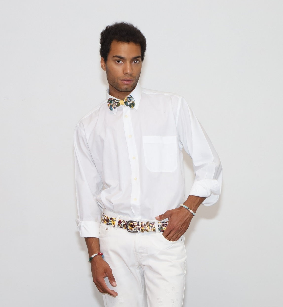 our model wearing white pants and a white shirt with painted bow tie and belt in a white background