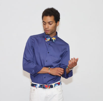 our model wearing white pants and a blue shirt with painted bow tie and belt in a white background