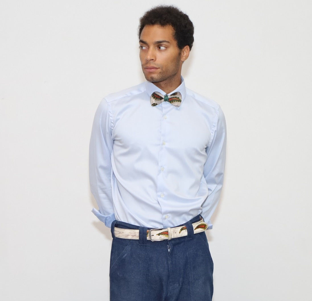 our model wearing blue jeans and a light shirt with painted bow tie and belt in a white background