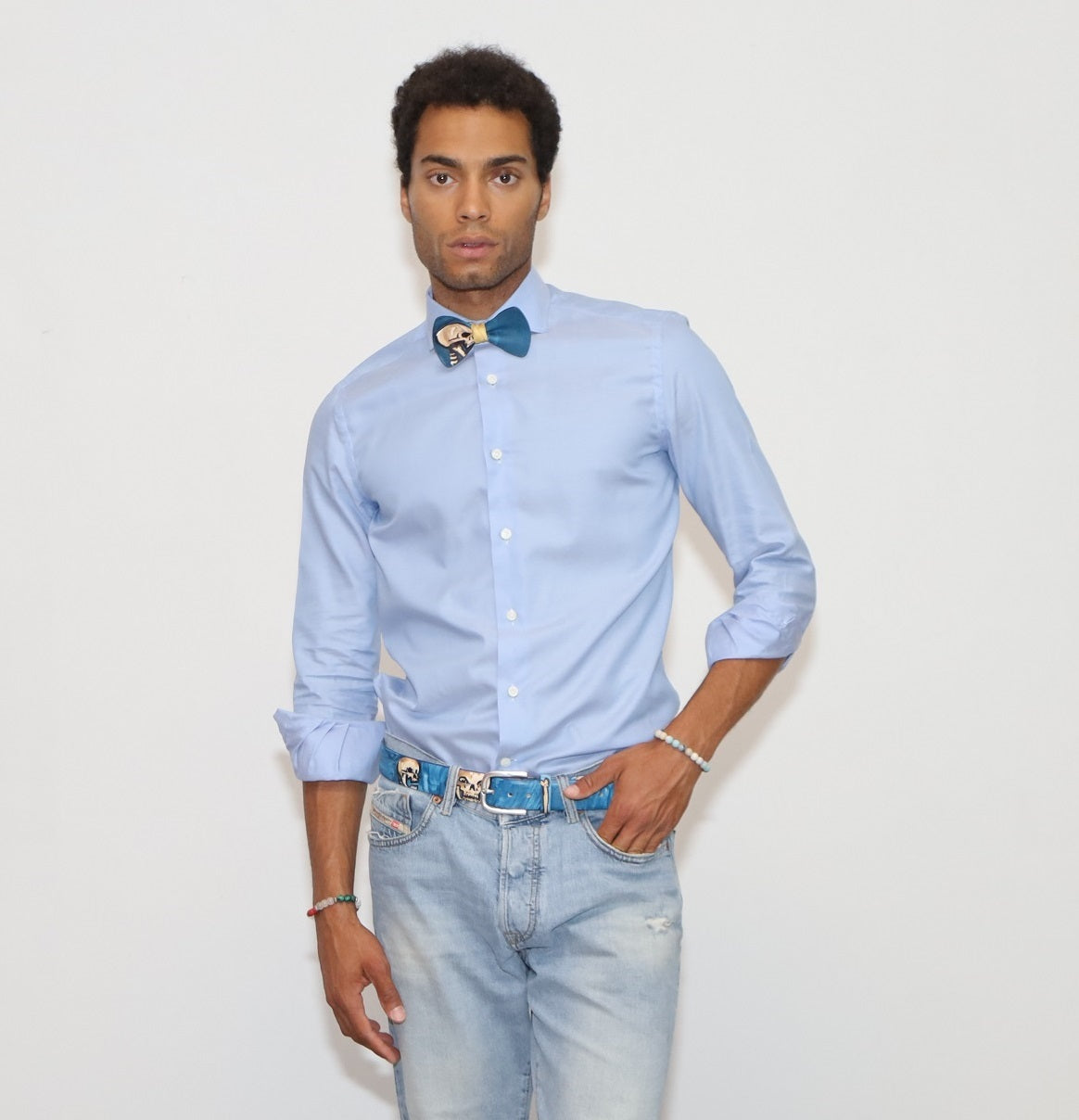 our model wearing light blue pants and a light blue shirt with painted bow tie and belt in a white background