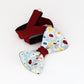 harlequin's choice hand painted bow tie with blue yellow and red dots on a light blue background