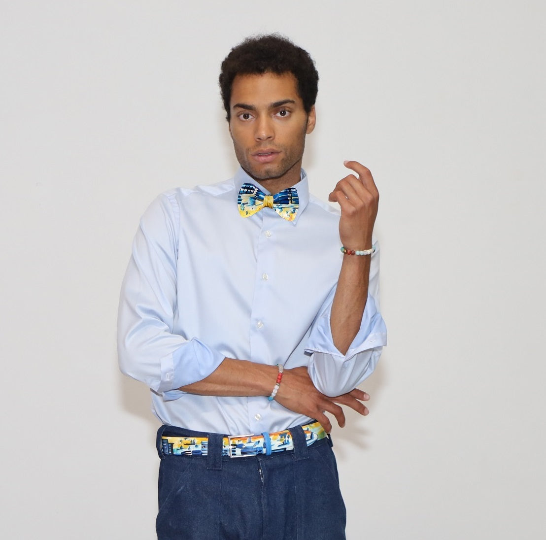 our model wearing blue jeans and a white shirt with painted bow tie and belt in a white background