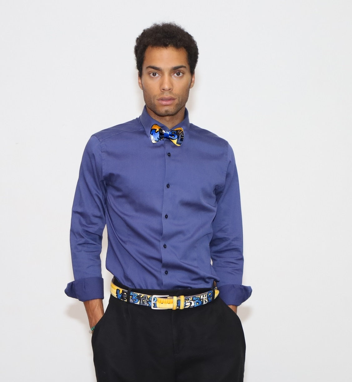 our model wearing black pants and a blue shirt with painted bow tie and belt in a white background